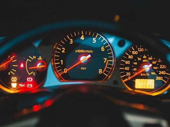 Car dashboard at night with instrument cluster lit up