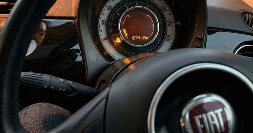 Fiat 500 amber triangle warning light on with blank dot-matrix display showing no fault message, odometer reading 67412 miles