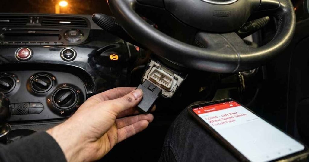 OBD-II scanner plugged into a Fiat 500 diagnostic port showing fault code C0040 left rear wheel speed sensor circuit fault on a smartphone screen