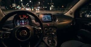 Fiat 500 dashboard showing multiple amber and red warning lights illuminated on the instrument cluster at night
