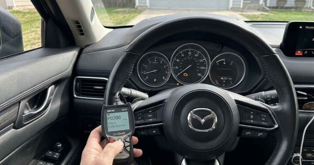 OBD-II scanner reading a diagnostic trouble code on a Mazda